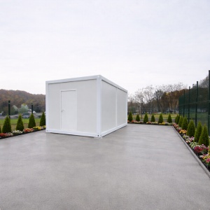 Container alb compact fotografiat din depărtare pe platformă de beton