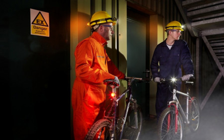 Lampă de semnalizare Atex WOLF ML-15W Z1 (alb) utilizată de muncitori pentru a semnaliza pericole într-un depozit întunecat