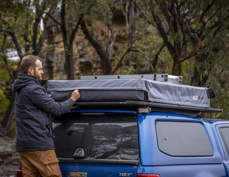 Bărbat instalând pe plafonul mașinii cort de plafon auto Ford/ARB Flinders