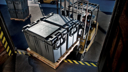 Cutii suprapozabile Peli 0500 Transport Case utilizate într-un depozit pentru a proteja diverse echipamente la un transport