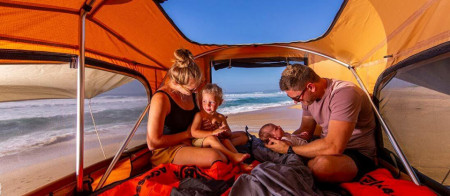 Familie stând la mare în cortul de plafon auto Ford/ARB Flinders