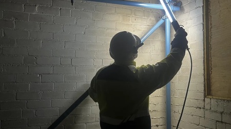 Muncitor folosind o lampa inspectie certificata ATEX Wolf TY-300 pentru a verifica structura unei cladiri