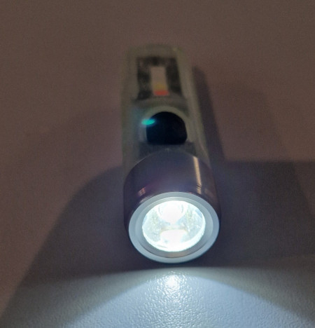 Lanternă Foton Mini S11 breloc multifuncțional testată într-o cameră întunecată