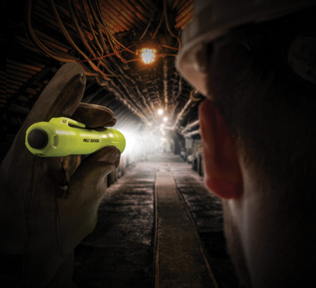 Lanternă profesională antiex Peli 2315Z0 utilizată de un muncitor pentru a vedea în întuneric într-un tunel