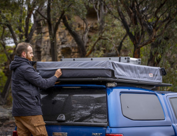 Bărbat instalând pe plafonul mașinii cort de plafon auto Ford/ARB Flinders