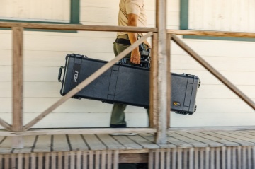 Soldat ce transportă în siguranță arma de foc într-o geanta rigida Peli 1750 Long Case Bej 