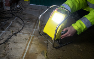 Proiector ATEX/IECEx Mini Worklite™ WL-50 utilizat de un muncitor pentru a lumina un depozit