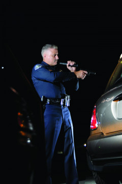 Lanternă de poliție Peli Tactical Flashlight 7060 utilizată de un polițist într-o intervenție