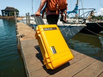 Cercetator folosind troler de protectie Peli 1615 Air Case galben pentru a transporta echimpamentul in siguranta pe mare