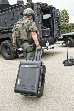 Troler de protectie Peli 1607 Air Case utilizat de un soldat pentru a transporta echipamentul la vehicul.