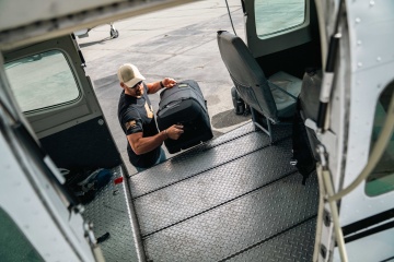 Pilot ce utilizează troler hibrid Peli Aegis 32" Rolling Hybrid Duffel cu 2 roti pentru a transporta în siguranță echipamentul.