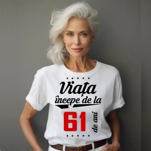 Femeie care poartă un tricou alb personalizat cu mesajul: ''Viața începe de la 61 de ani''