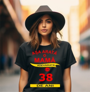 Femeie zâmbitoare purtând un tricou cu mesajul: ''Așa arată o mamă adevărată la 38 de ani''