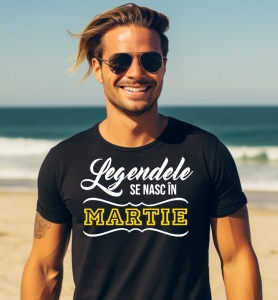 Un bărbat zâmbitor purtând un tricou negru cu mesajul: „Legendele se nasc în Martie”.