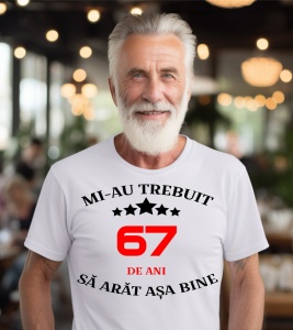 Un bărbat purtând un tricou alb cu mesajul: „Mi-au trebuit 67 de ani să arăt așa bine”