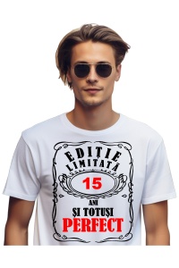 Un bărbat purtând un tricou alb cu mesajul: „Ediție limitată, 15 ani și totuși perfect”. Bărbatul afișează o atitudine veselă și pozitivă.