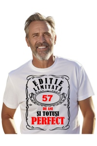 Un bărbat purtând un tricou alb cu mesajul: „Ediție limitată, 57 de ani și totuși perfect”. Bărbatul afișează o atitudine veselă și pozitivă.