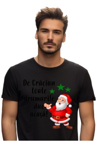 Bărbat purtând un tricou negru cu un design de Crăciun, care include imaginea lui Moș Crăciun vesel și textul ‘De Crăciun toate drumurile duc acasă!’, alături de trei steluțe verzi.