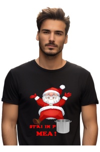 Bărbat purtând un tricou negru cu un design amuzant de Crăciun, înfățișându-l pe Moș Crăciun într-o poziție comică deasupra unei oale, alături de textul ‘Stai în poala mea!'