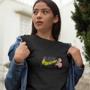 Femeie purtând un tricou negru cu un design grafic ce include textul 'NIKE' și un personaj stilizat(Catwoman), pozând afară și purtând o jachetă de blugi deschisă.