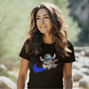 Femeie cu părul lung și ondulat, purtând un tricou negru cu un design ce reprezintă un personaj adorabil albastru(Stitch) cântând la chitară, cu o șapcă și aripi roz, așezat pe logo-ul unui brand sportiv de culoare albastră. Femeia zâmbește și este surpri