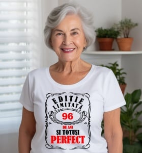 Femeie care poartă un tricou alb personalizat cu mesajul: ''96 de ani si totusi perfect''.