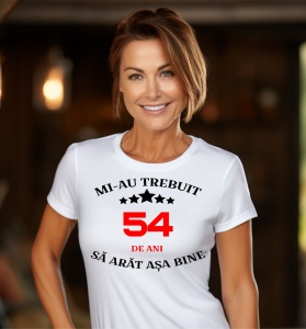 Femeie care poartă un tricou alb personalizat cu mesajul: ''Mi-au trebuit 54 de ani sa arat asa bine''