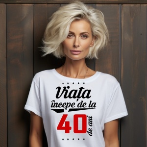 O femeie purtând un tricou alb cu textul  'Viața începe de la 40 de ani'. Fundal din lemn cu diferite nuanțe de maro și verde.