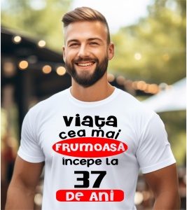Un bărbat purtând un tricou alb cu textul ''Viața cea mai frumoasă începe la 37 de ani''.