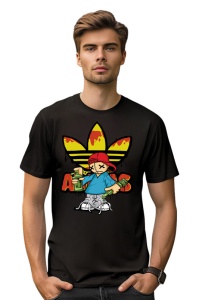 Bărbat tânăr cu păr scurt, purtând un tricou negru cu un design grafic colorat, reprezentând un personaj cu pălărie roșie și vopsea pe un fundal de trei linii galbene, într-o atmosferă urbană.