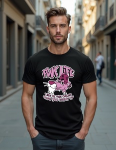 Un bărbat care poartă un tricou negru cu un design animat al unei pisici roz și un mesaj care spune 'PINK LIFE, LIFE IS THE COLOR THAT YOU PAINT IT'. Pisica se află într-o poziție relaxată și se uită către privitor.