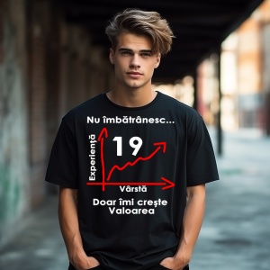 Un tânăr purtând un tricou negru cu mesajul: „Nu îmbătrânesc... Doar îmi crește valoarea” și un grafic care indică vârsta de 19 ani pe axa vârstei și experienței. Tânărul se află într-un cadru urban, cu un fundal de clădiri și umbre.