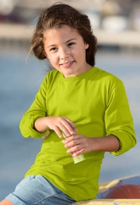 Fată zâmbitoare purtând un tricou galben lime și pantaloni scurți, ținând un baton de înghețată, în timp ce stă pe o barcă lângă apă