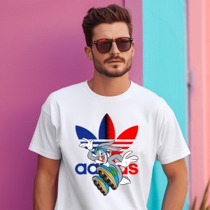 Un bărbat purtând ochelari de soare și un tricou alb cu design adidas, ce include personajul Bugs Bunny pe un skateboard, cu un logo colorat roșu și albastru, pozând lângă un perete în culori vibrante de roz și albastru.