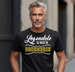 Un bărbat cu păr grizonat, purtând un tricou negru cu mesajul: „Legendele se nasc în Decembrie”.
