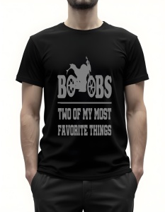 Bărbat purtând un tricou negru cu textul ‘Boobs - Two of my most favorite things’ și o ilustrație de motocicletă stilizată între litere.