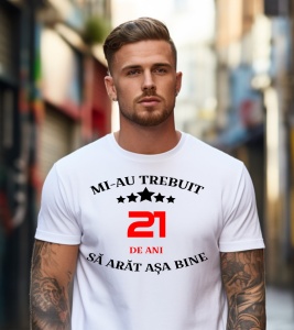 Un bărbat purtând un tricou alb cu mesajul: „Mi-au trebuit 21 de ani să arăt așa bine”