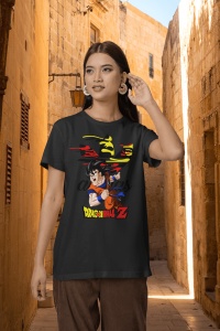 Femeie purtând un tricou negru cu un design grafic ce prezintă un personaj din Dragon Ball Z, pozând pe o stradă îngustă și luminată dintr-un oraș cu arhitectură tradițională.
