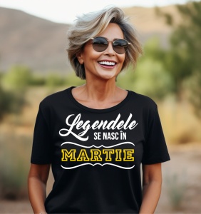 Femeie care poartă un tricou negru personalizat cu mesajul: ''Legendele se nasc martie''.