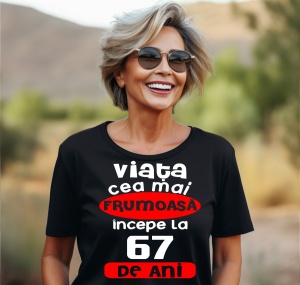 Femeie care poartă un tricou negru personalizat cu mesajul: ''Viata cea mai frumoasa incepe la 67 de ani''.