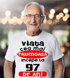 Un bărbat purtând un tricou alb cu textul ''Viața cea mai frumoasă începe la 97 de ani''.