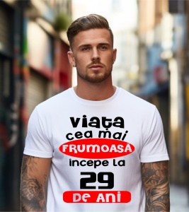 Un bărbat purtând un tricou alb cu textul ''Viața cea mai frumoasă începe la 29 de ani''.