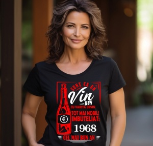 Femeie zâmbitoare purtând un tricou negru cu un mesaj în română despre vin, în care se menționează că este ca un vin bun care devine mai nobil cu vârsta, îmbuteliat în 1968, cel mai bun an.