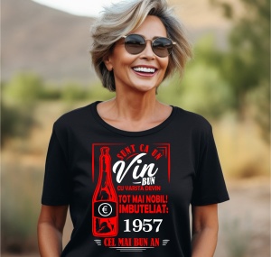 Femeie zâmbitoare purtând un tricou negru cu un mesaj în română despre vin, în care se menționează că este ca un vin bun care devine mai nobil cu vârsta, îmbuteliat în 1957, cel mai bun an.