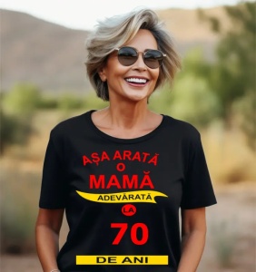 Femeie zâmbitoare purtând un tricou cu mesajul: ''Așa arată o mamă adevărată la 70 de ani''