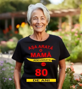 Femeie zâmbitoare purtând un tricou cu mesajul: ''Așa arată o mamă adevărată la 80 de ani''