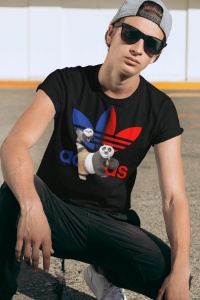 Tânăr purtând ochelari de soare și un tricou negru cu un design colorat, care include personaje de animație(KungFu Panda Po) și un logo reinterpretat, pozând într-un cadru urban.