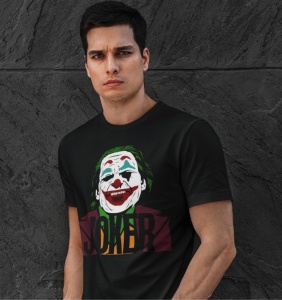 Bărbat purtând un tricou negru cu un design stilizat al personajului Joker, pe un fundal gri închis, textul 'JOKER' fiind vizibil în partea de jos a designului.