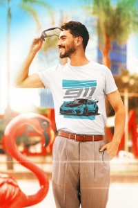 Bărbat zâmbitor purtând un tricou alb cu designul unei mașini sport și textul '911 GT RS', ținând o pereche de ochelari de soare în mână, în fața unui decor tropical cu flamingo decorativ și vegetație în fundal.