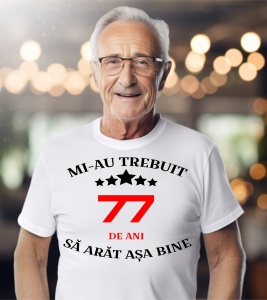 Un bărbat purtând un tricou alb cu mesajul: „Mi-au trebuit 77 de ani să arăt așa bine”